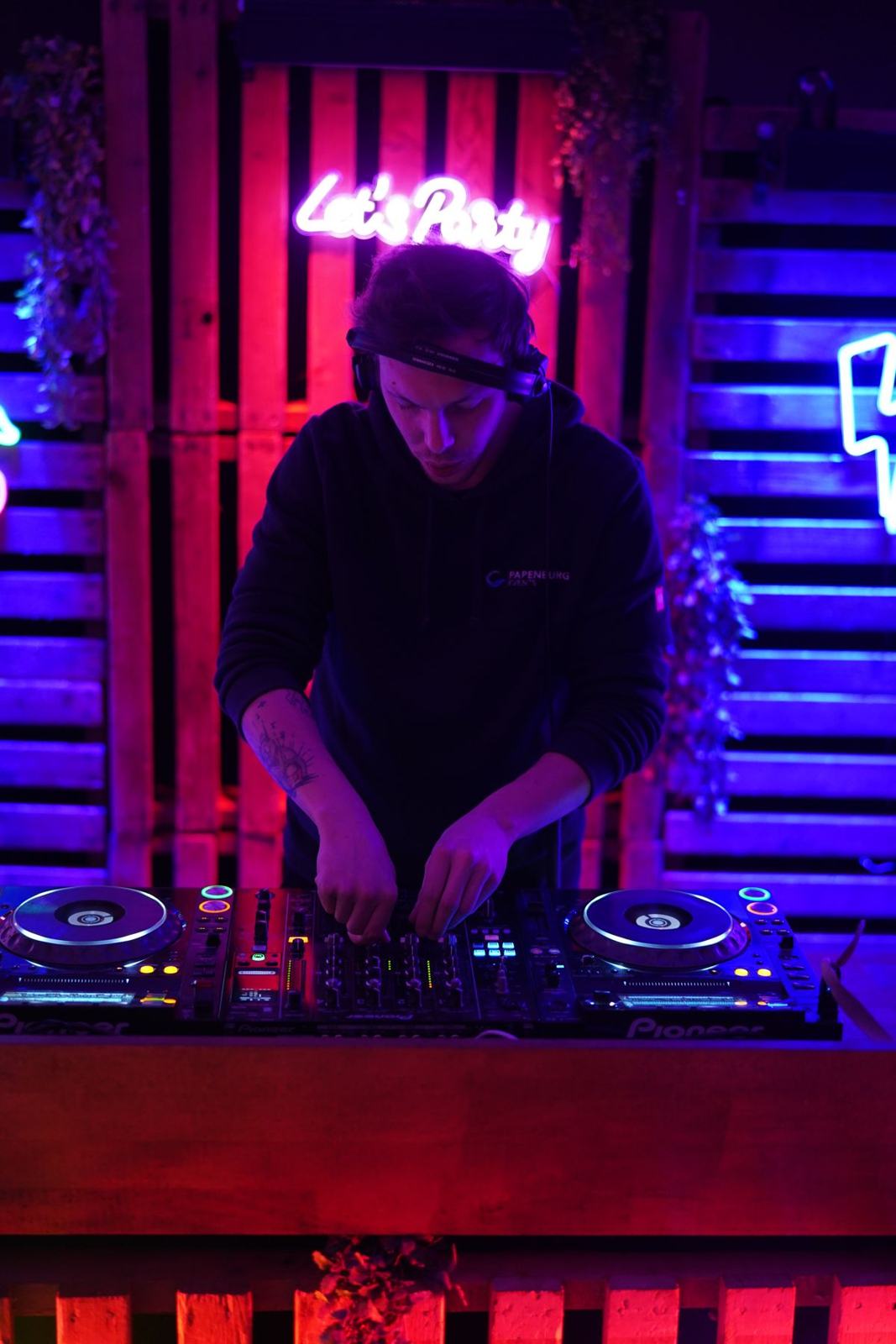 Milo mixing under a pink neon sign